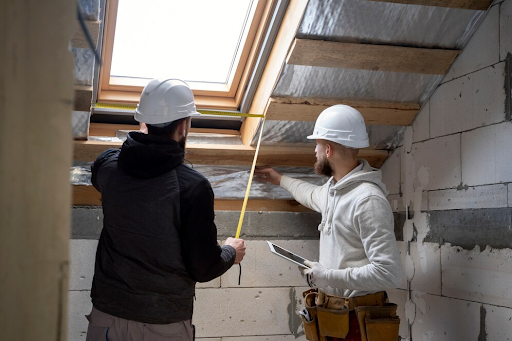 artisans entrain d'isoler une toiture